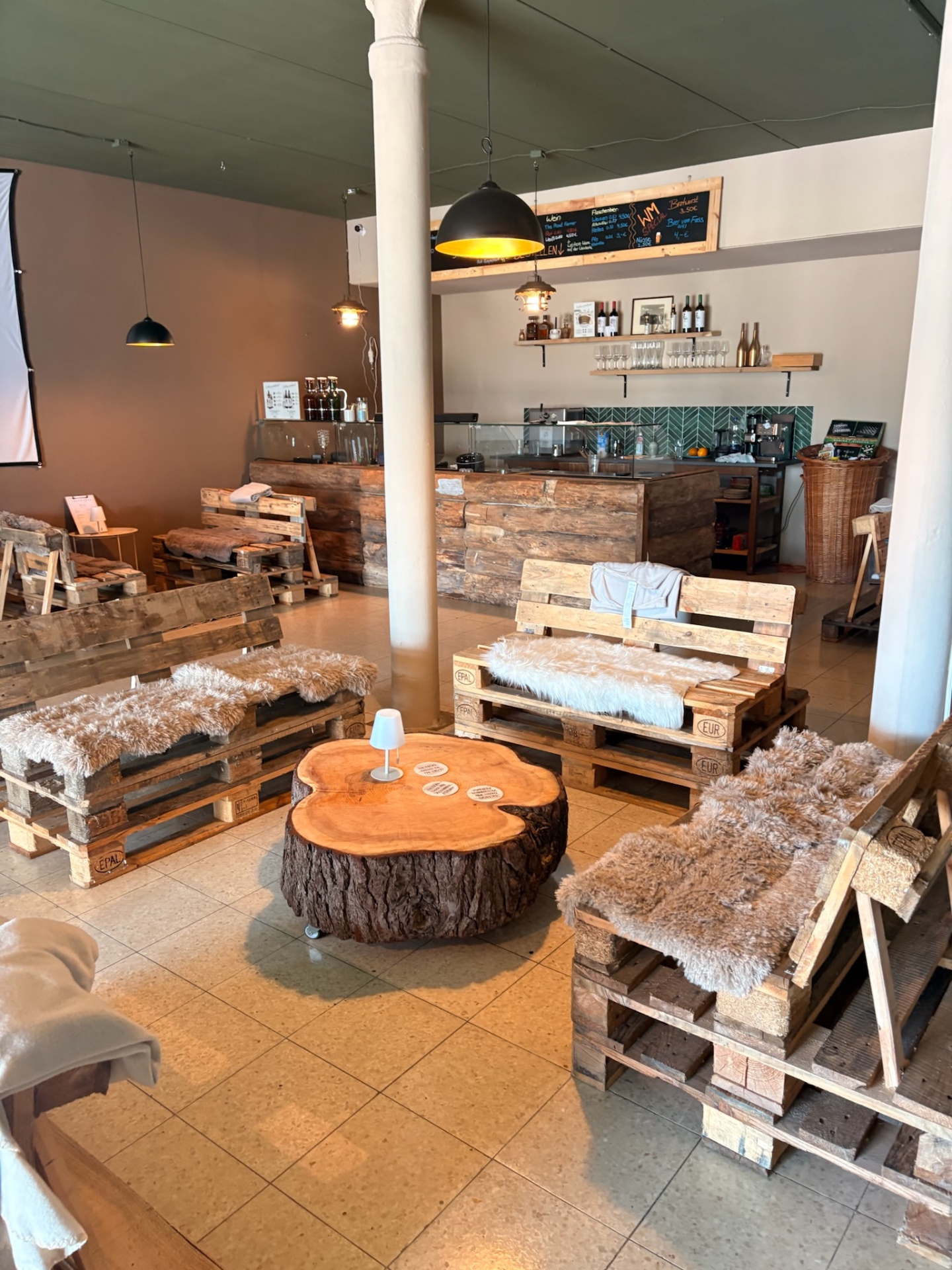 Innenraum der Lager-Bar Greene in Einbeck mit Palettenlounge und Baumscheiben-Tisch